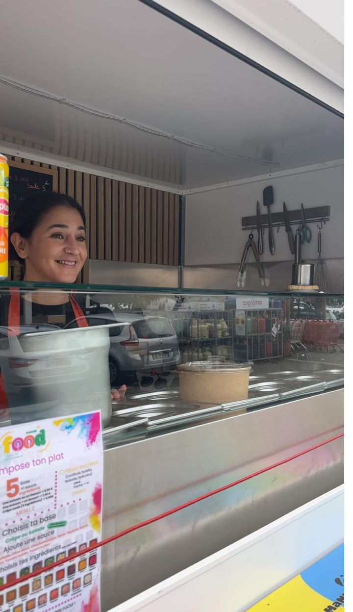 Sourire derrière le comptoir du food truck DaMaNN FoOd, plats préparés avec soin